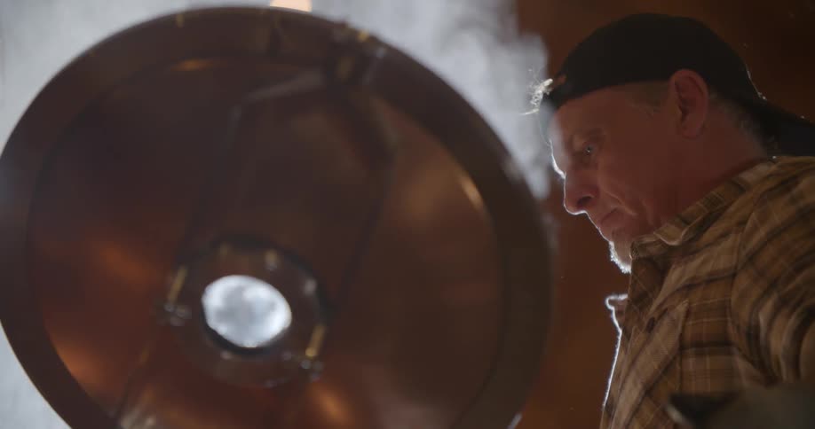 A man opens a hatch and releases steam into the air