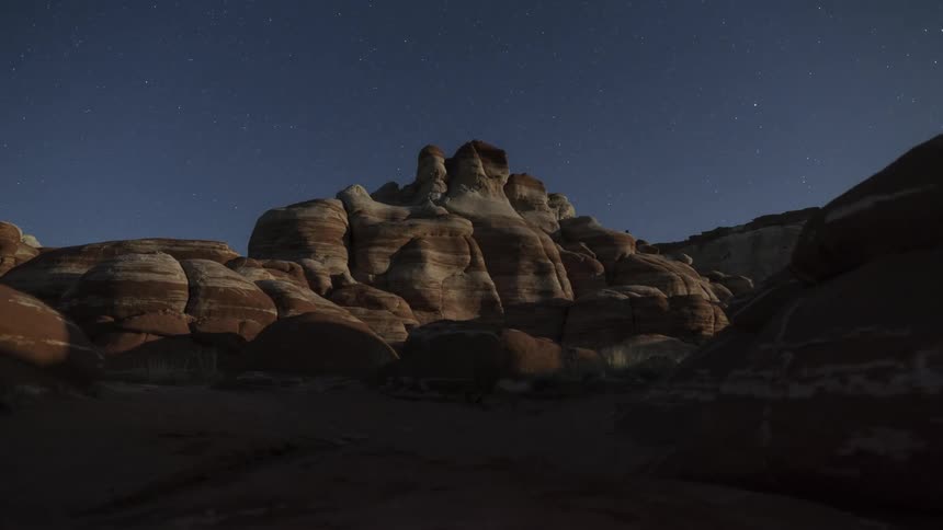 Moonlight quickly spreads across large rocks casting shadows