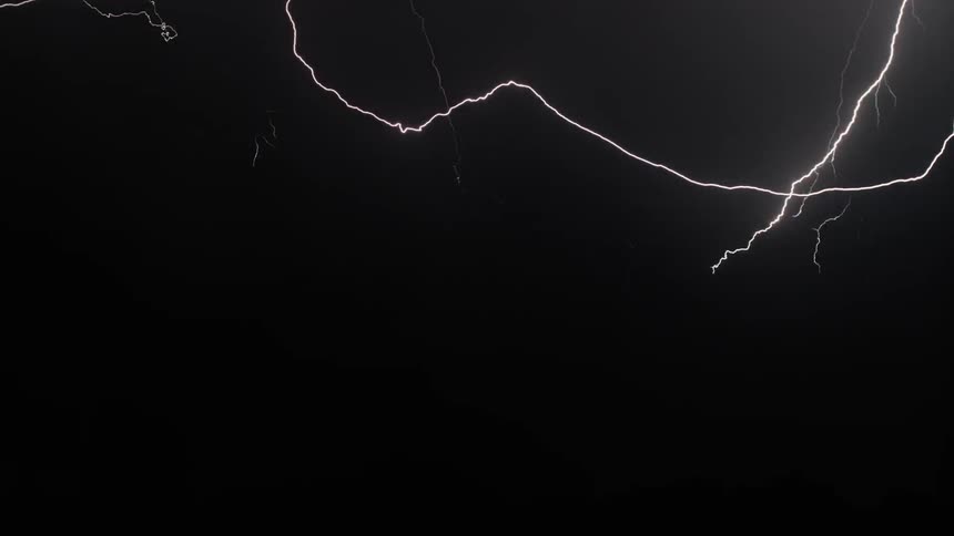 The night sky suddenly lights up with lightning