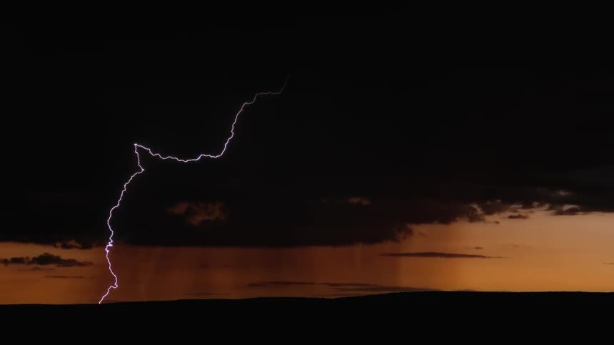 Lightning strikes flat land at sunset