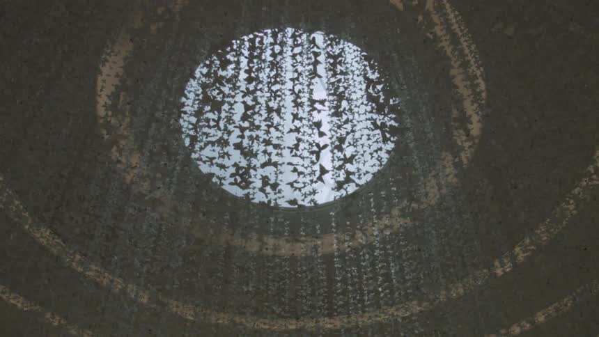 Decorations hang from a ceiling with a round window