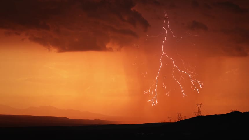 Rain and lightning pour down onto hilly land