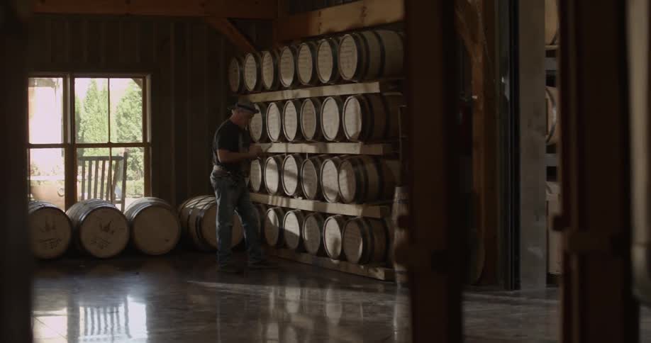 A man is working writing things down in a distillery