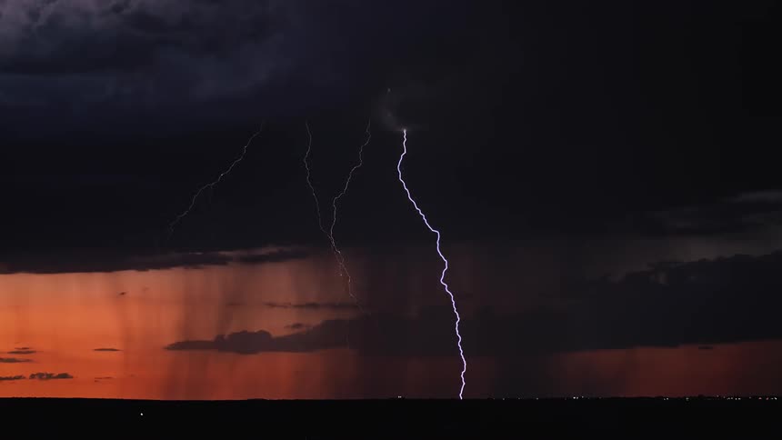 Lightning flashes during a storm at sunset