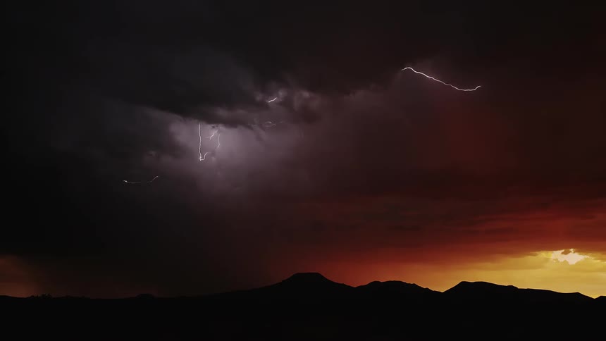 Lightning flashes and moves within the body of a storm at dusk