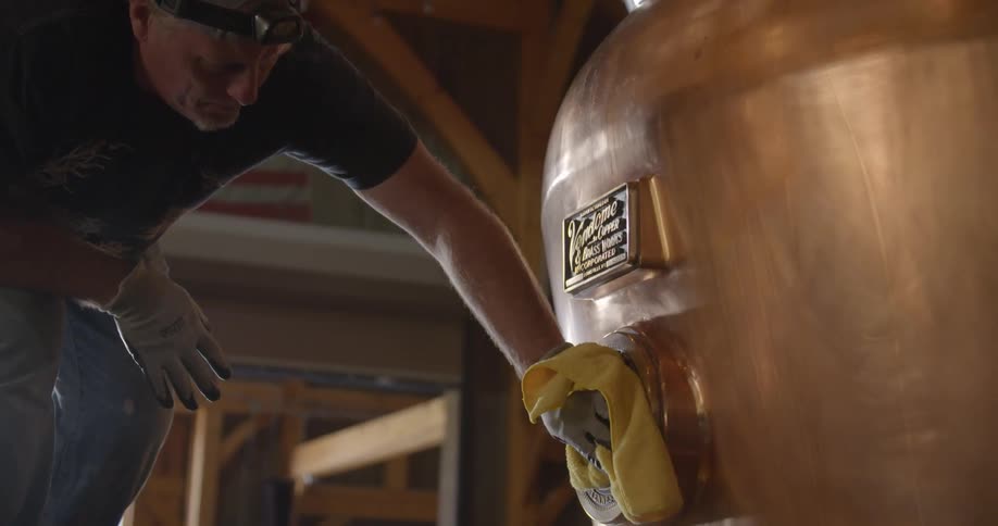 A man is polishing a brass machine