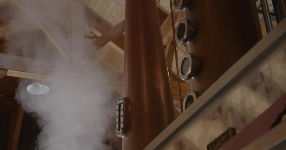 Man unscrews a small door on a kettle and steam rises up