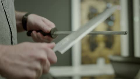 A man sharpens a kitchen knife