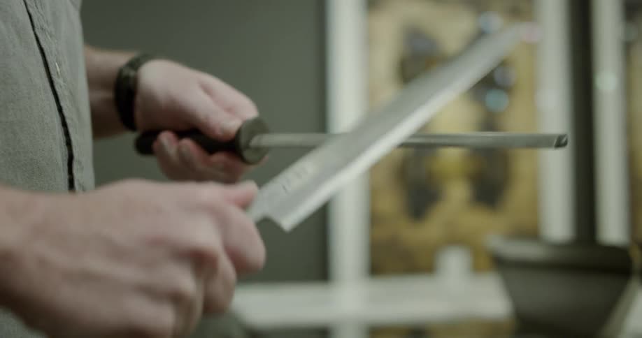A man sharpens a kitchen knife