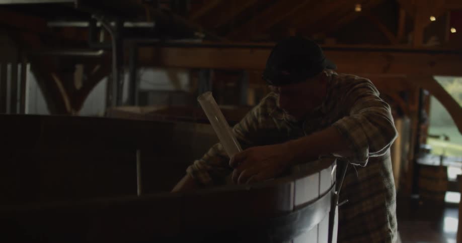 A man is testing the brew in a distillery