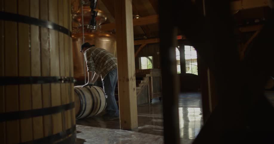 Man rolls a barrel in a workshop