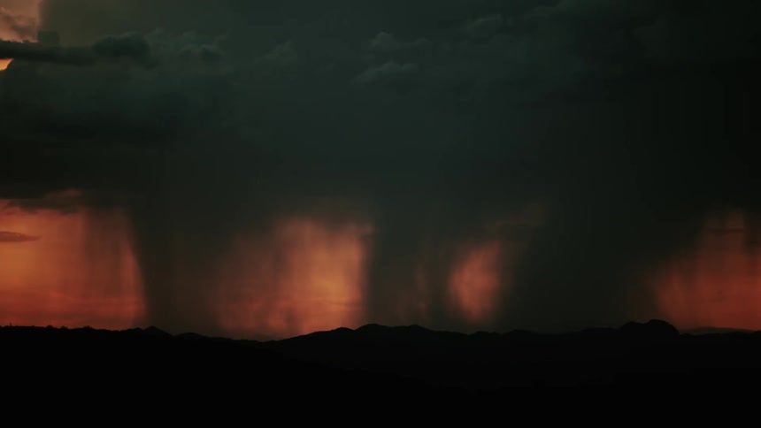 Rain pours down on hills as lightning flashes
