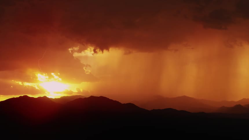 Lightning flashes from rain clouds at sunset