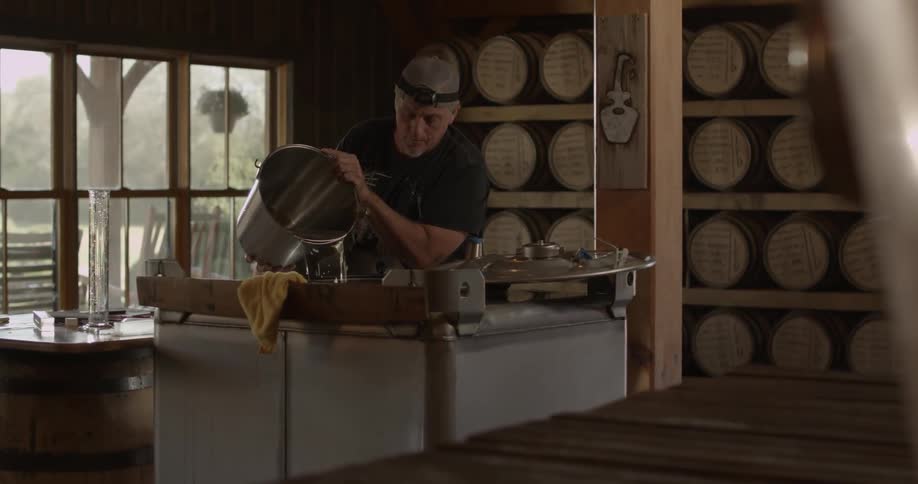 Man pours water into a large square container