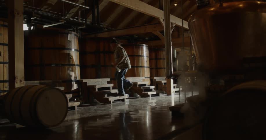 A man is walking through a distillery