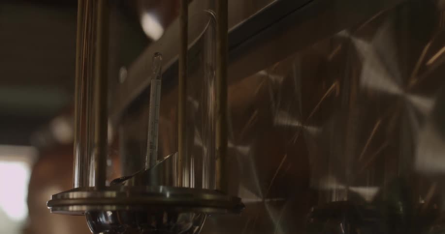 A thermometer bobs in fluid in an industrial setting