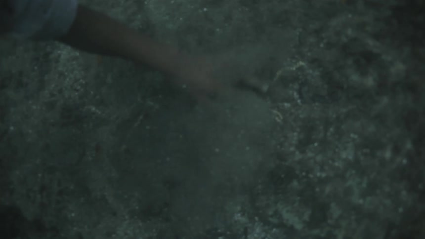 Man underwater grabs a necklace and jumps up
