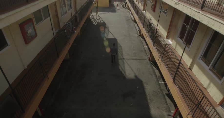 A man walks between two apartment complexes