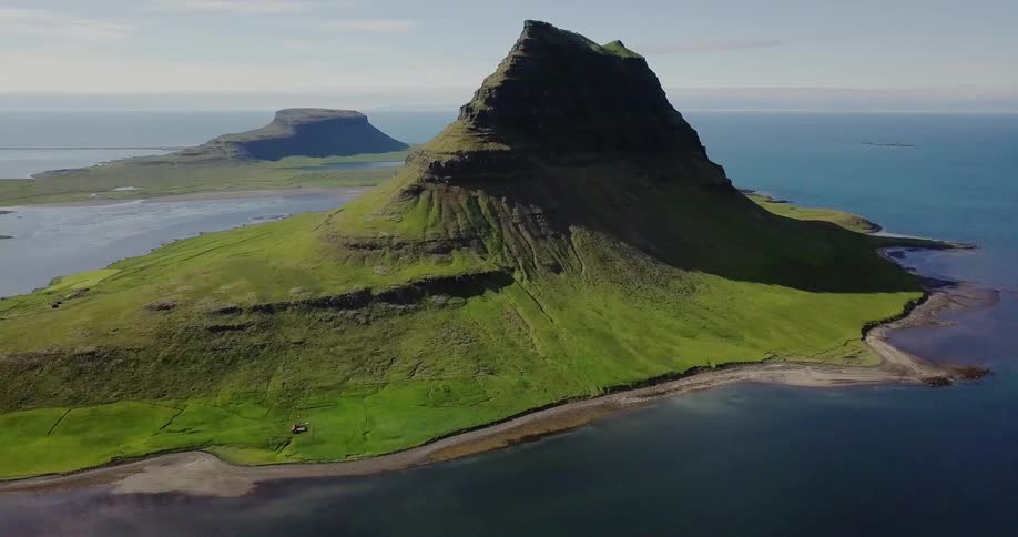 An island with a mountain peak is shown in the ocean
