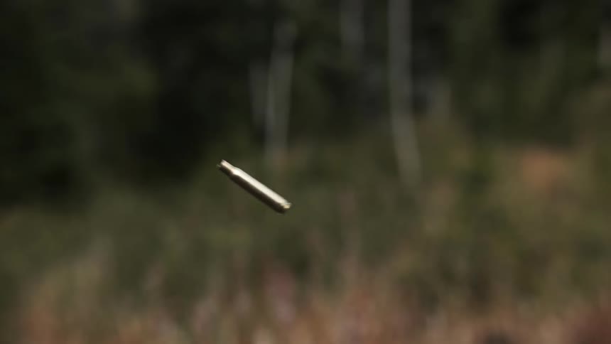 A bullet casing rotates as it flies through the air