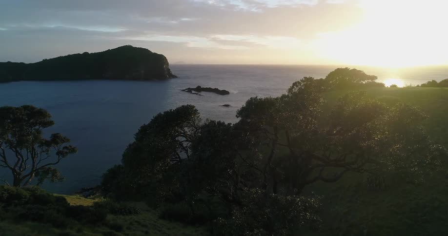 Sun shining over water and hills