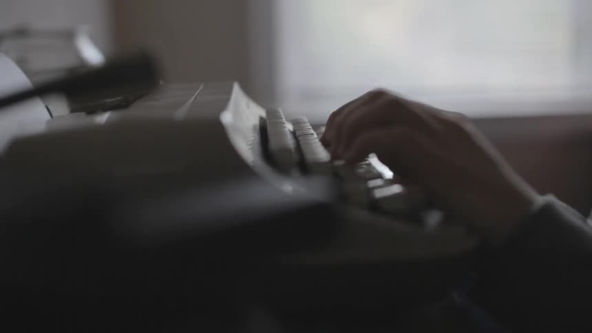 Hands typing on a typewriter