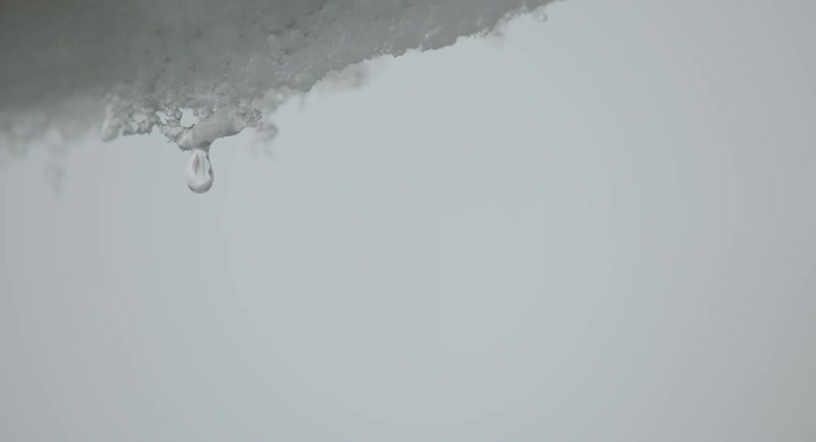 Close up of water dripping off of snow