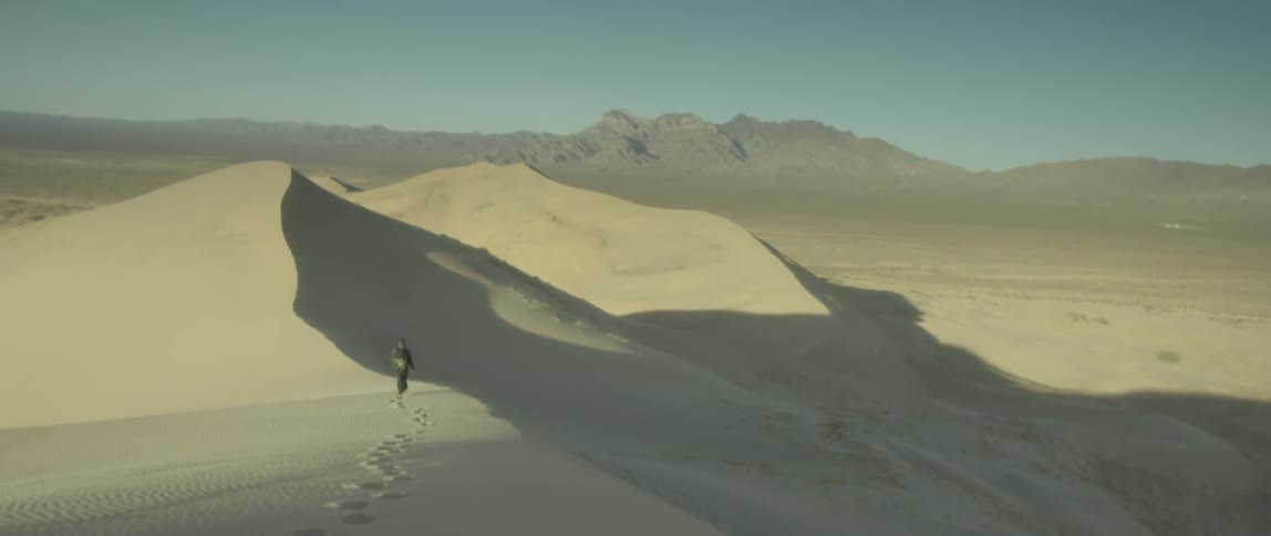 Man walking in the sand in a large desert