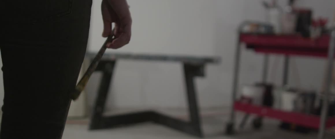 Man holding paint brush in front of empty canvas