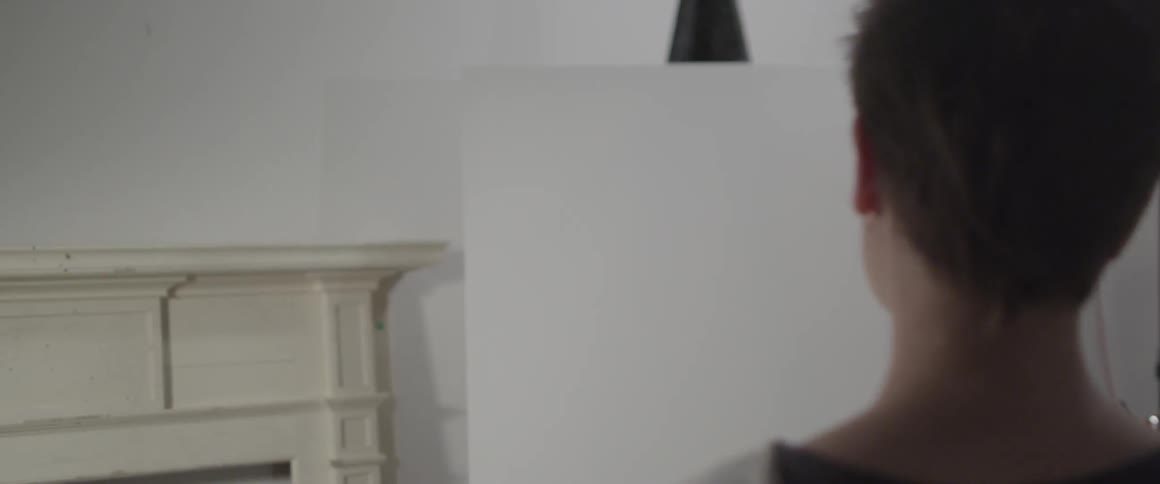 Woman stares forward towards an empty canvas