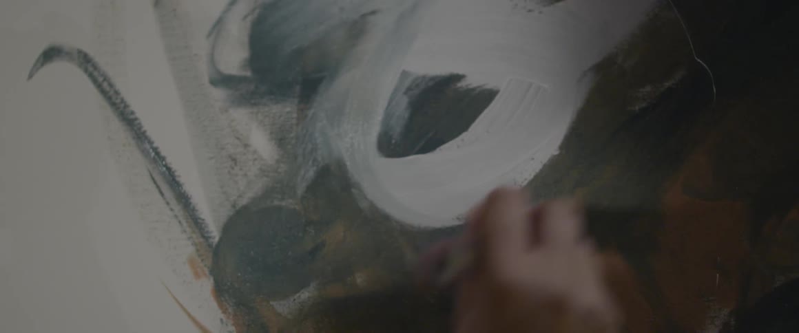 Woman uses white paint on a canvas