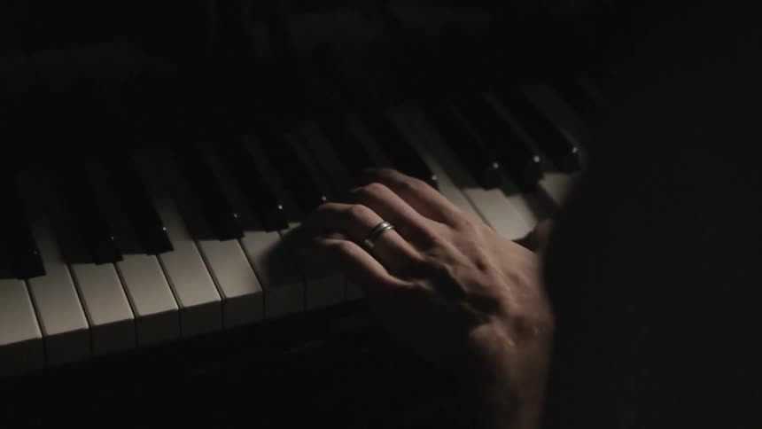 A person with their hand on a piano