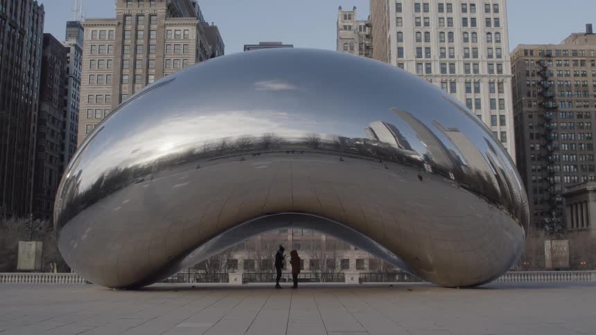People stand beneath the cloud gate sculpture in chicago