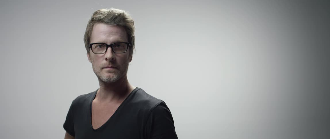 Man wearing glasses turns towards camera