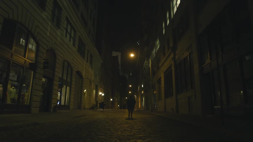 A person walking down the street at night
