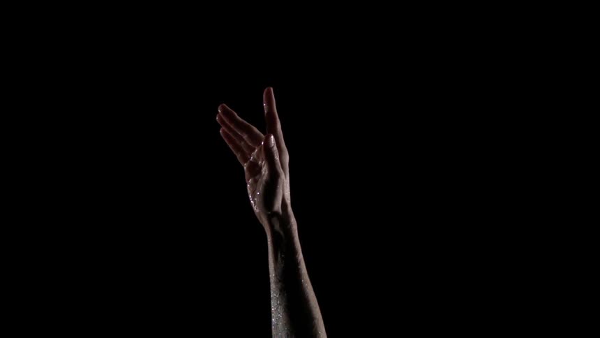 A hand reaching upwards against a dark background