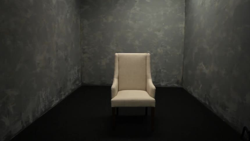 White chair in a dark room with no windows