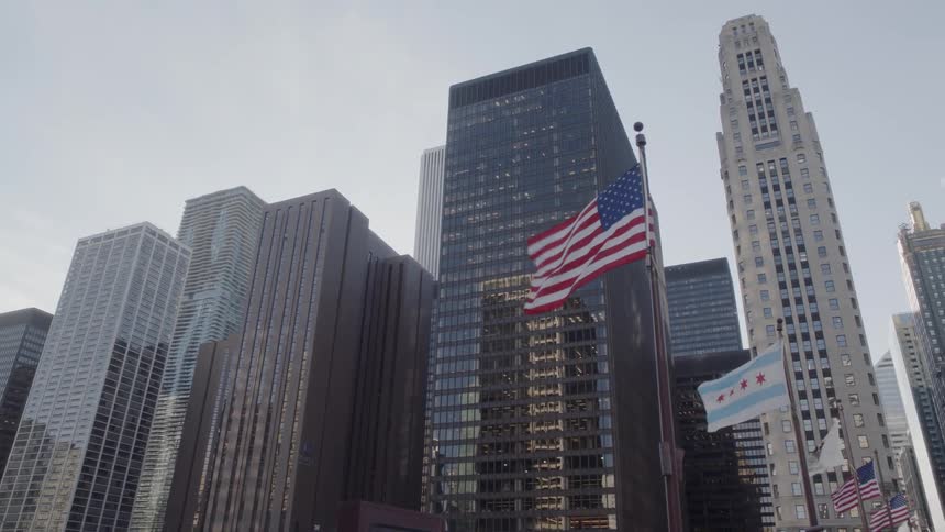 Flags waving in front of skyscrapers on a windy day