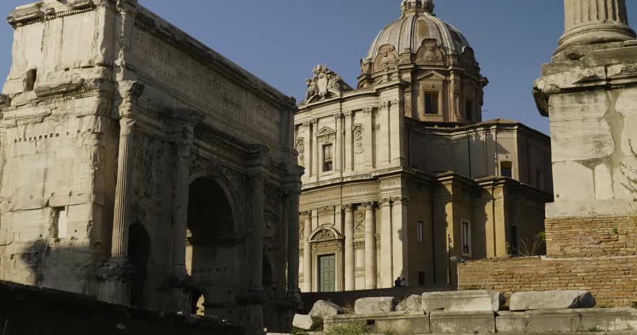 A stone archway stands in front of a domed building