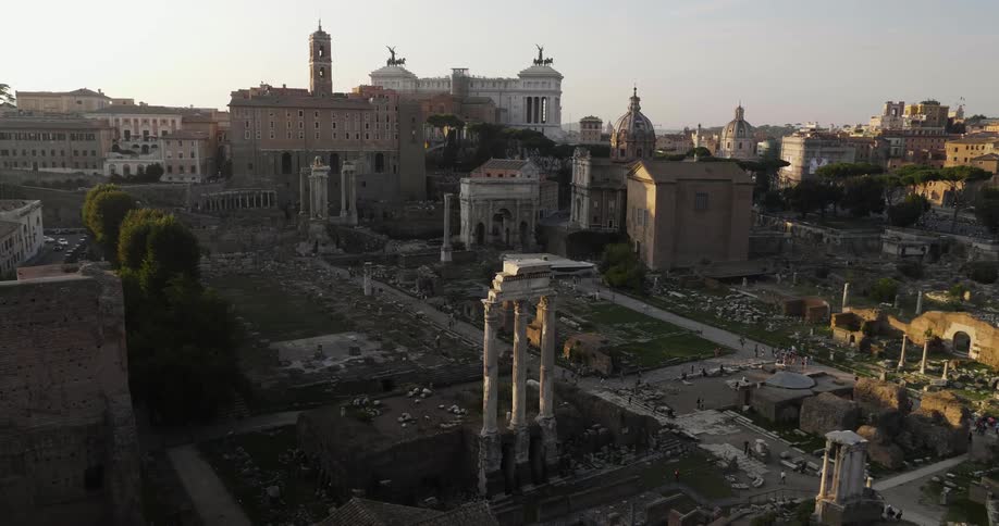 People walk near old ruins in a city