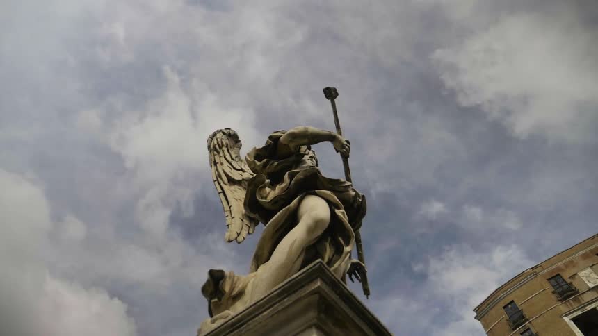 Clouds float above a stone statue