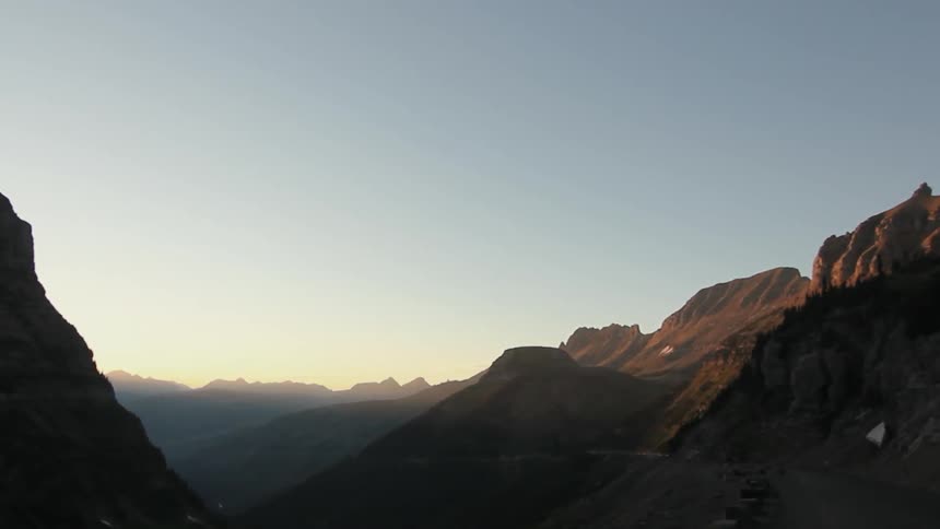 The sun is setting behind the mountains