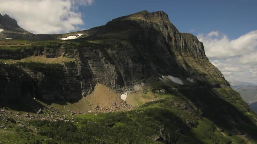 A rocky cliffside is shown in the mountains