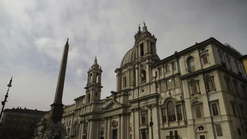 Clouds float above an ornate stone building