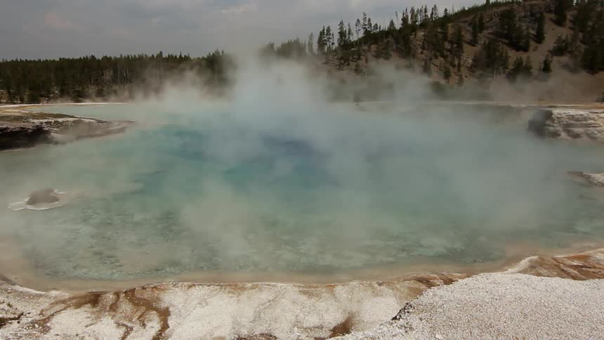 Steam rises from a hot spring pool