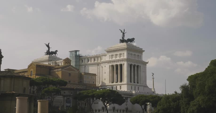Clouds float above buildings with statues