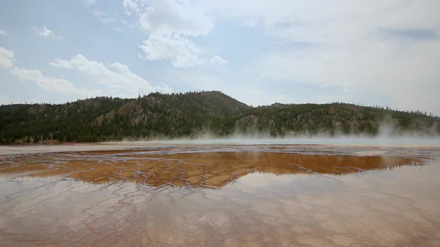 Steam rises from a shallow pool of water