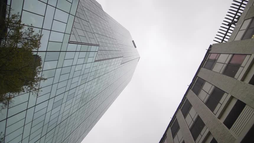 A tall glass building on a cloudy day