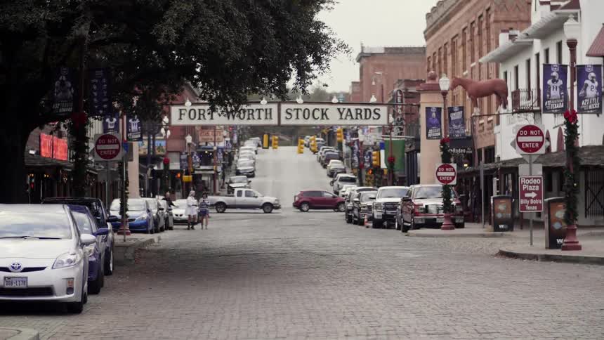 Vehicles driving down the street surrounded by buildings