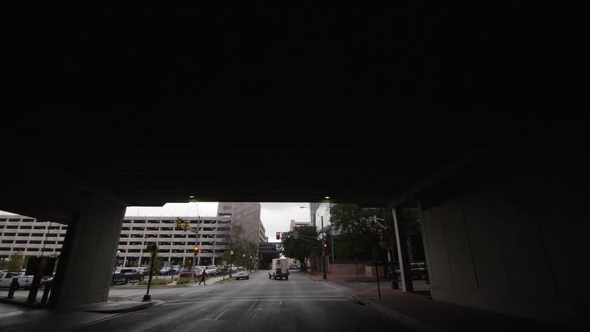 Under a bridge in a city on a cloudy day